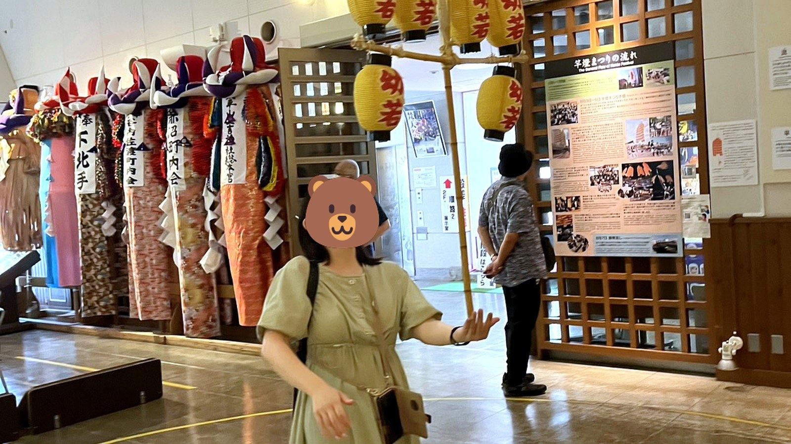 竿燈の展示を見上げる女性