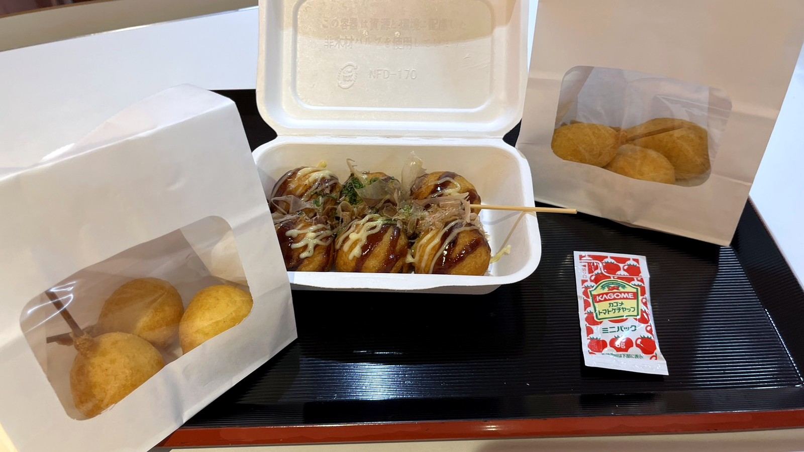 パックに入ったたこ焼きと紙袋入りの揚げ物
