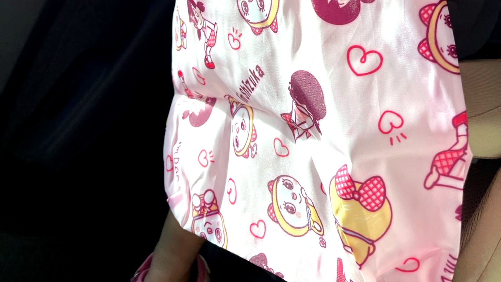 車内でキャラクター柄のバッグを持つ子ども