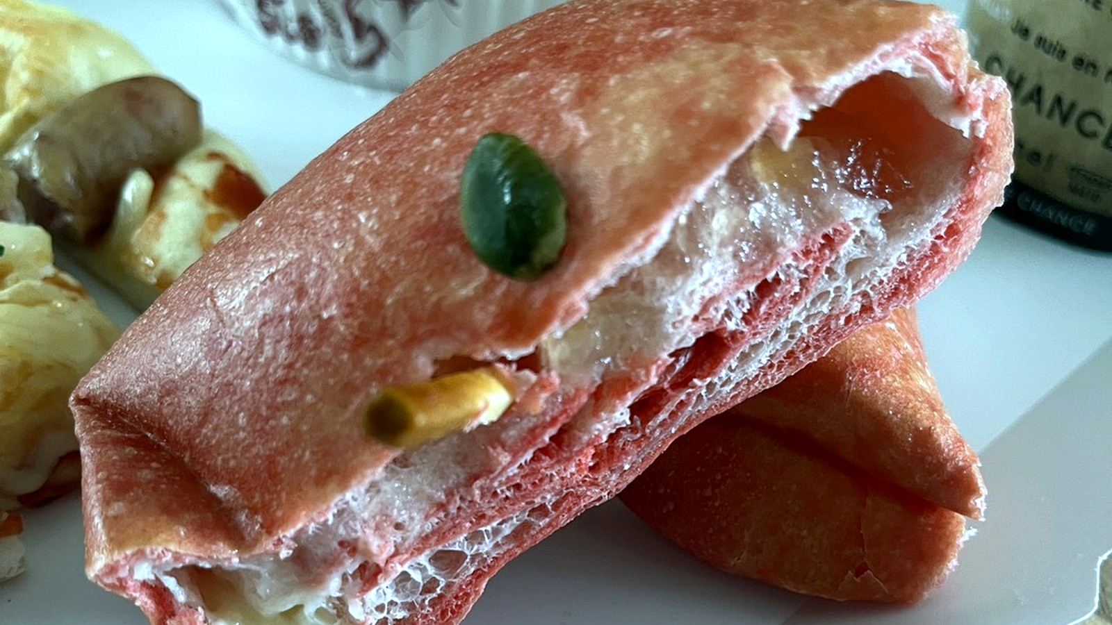 断面を見せたピンク色のパンと菓子パン