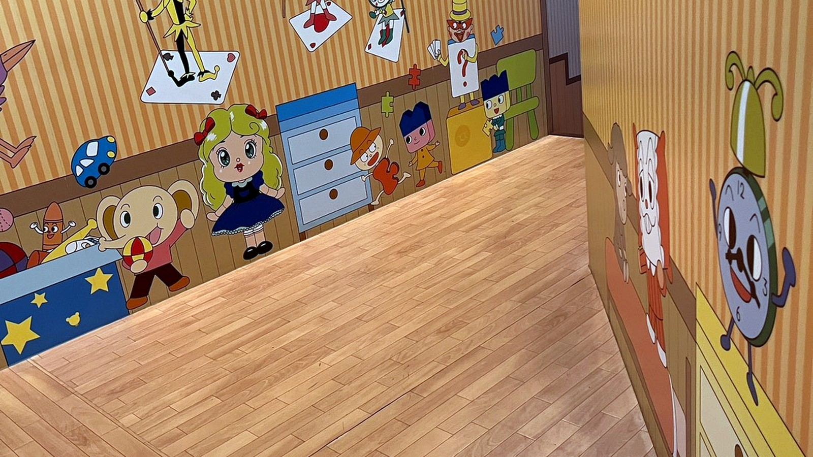 キャラクターのイラストが描かれた壁のある通路