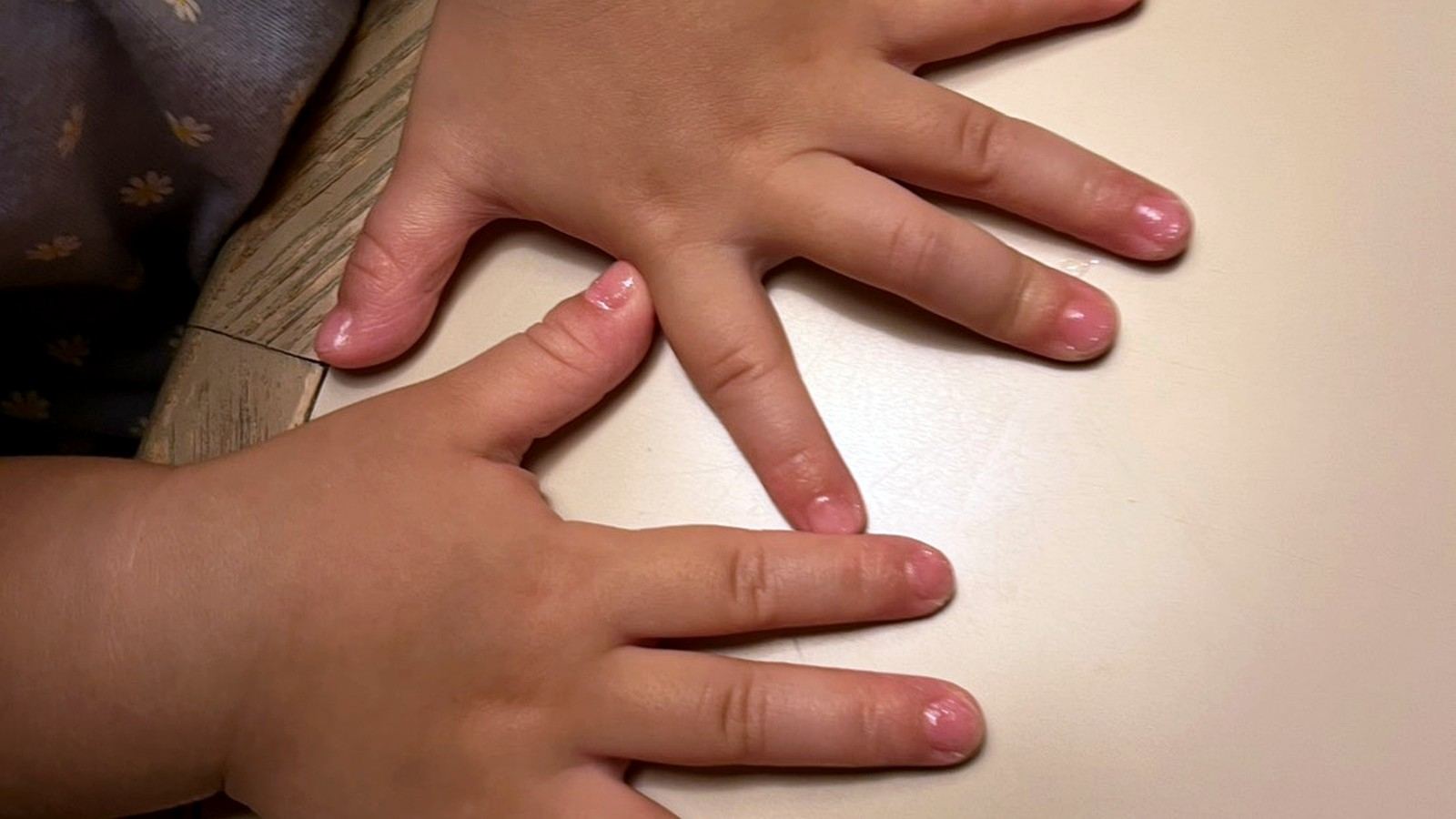 ピンクのネイルを塗った子供の両手